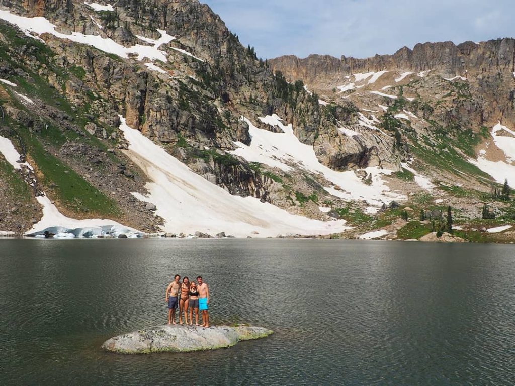 Students standing on a rock surrounded by water